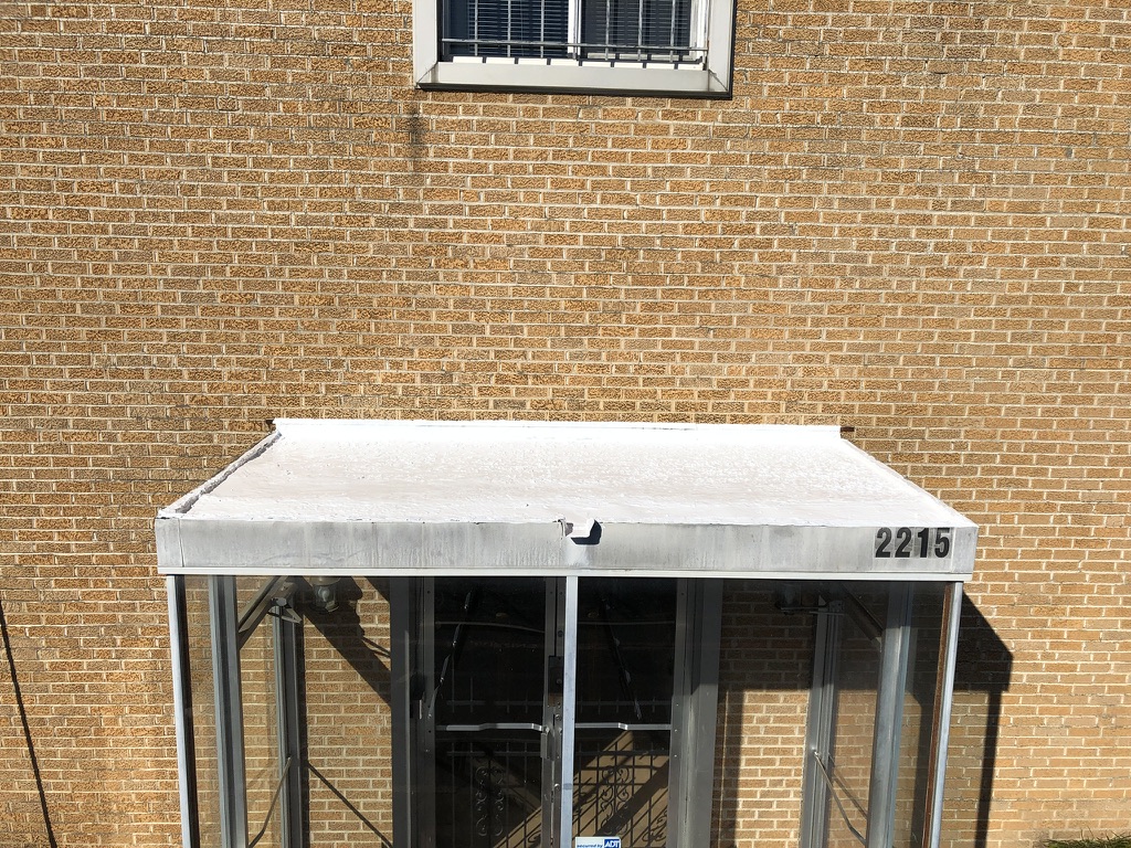 Silicone mastic applied at the scupper drain during commercial roof repair in South Dallas