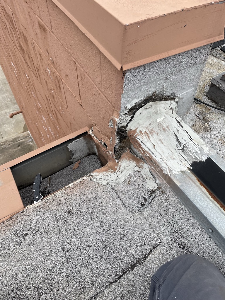 Failing flashing at a parapet wall on the Mod-Bit commercial roof, William D Tate Ave, Grapevine