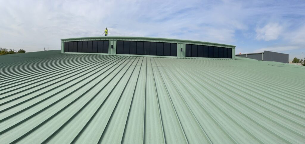 Power washing the 35,000 sq ft metal roof to remove dirt and oxidation, Irving, Texas
