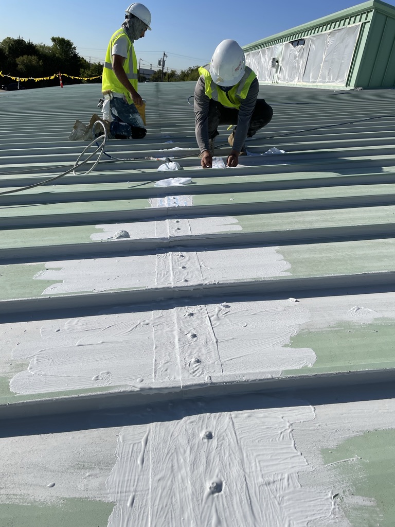 Crew rolling the base coat across the 35,000 sq ft metal roofing system, Irving, Texas