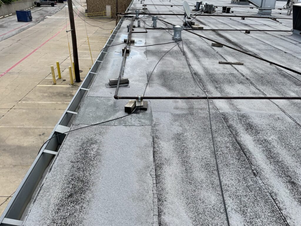 Aluminum RTU condenser coils knocked flat by hail on a commercial roof in Irving, Texas