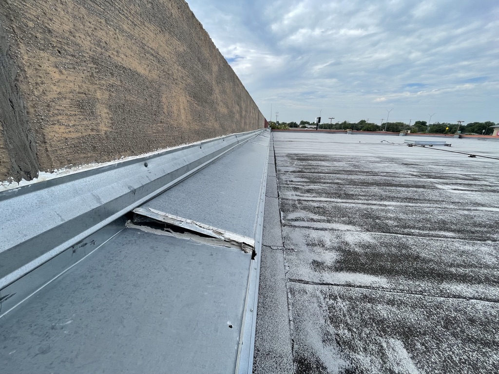 Loose granules washed into a ponding area on the Modified Bitumen roof, Irving, TX