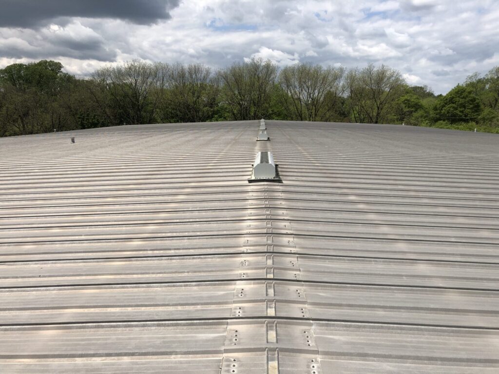 Power washing the industrial metal roofing system ahead of the silicone application, Little Rock, AR