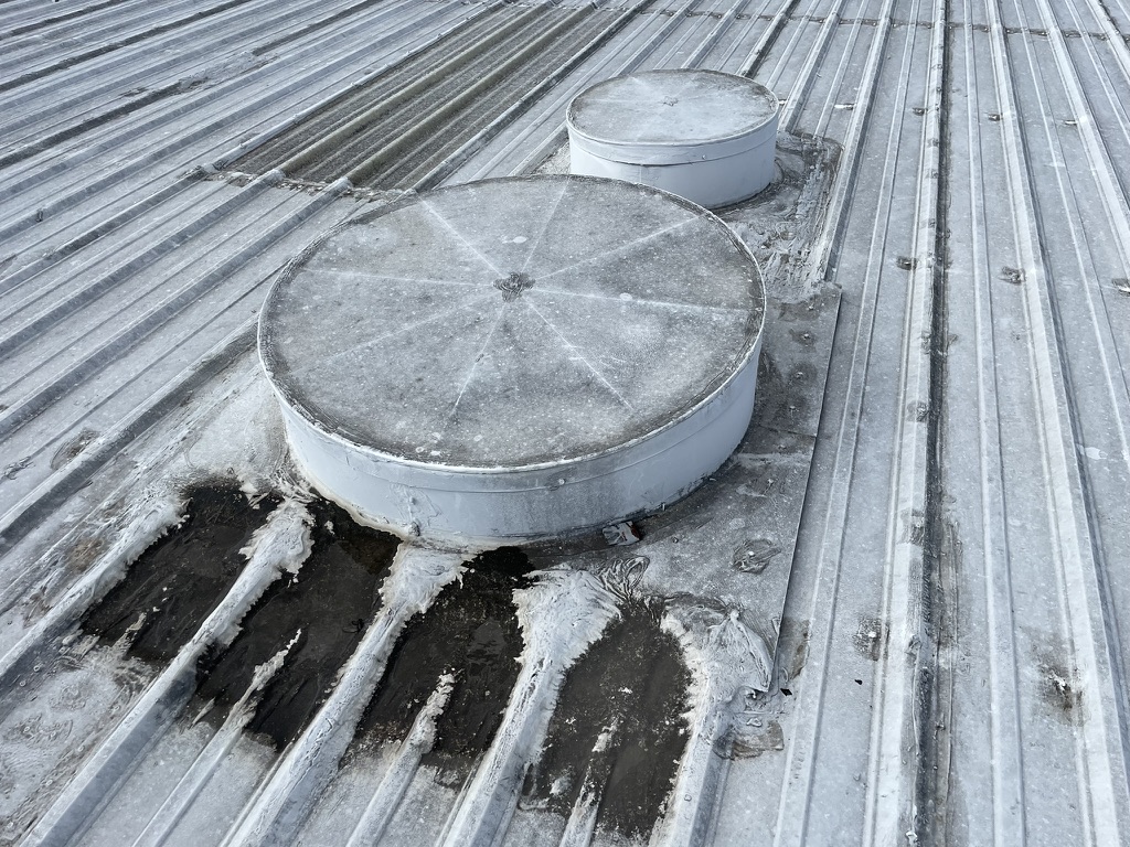Metal R-panel roof with failing acrylic coating at the AT&T property, 208 Sentry Dr, Mansfield, TX