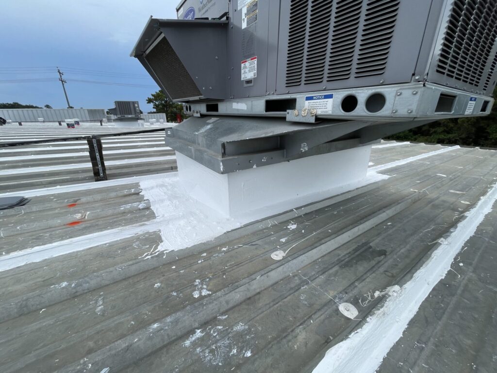 Silicone coating detailed and cured around a rooftop HVAC unit curb, Conroe, TX
