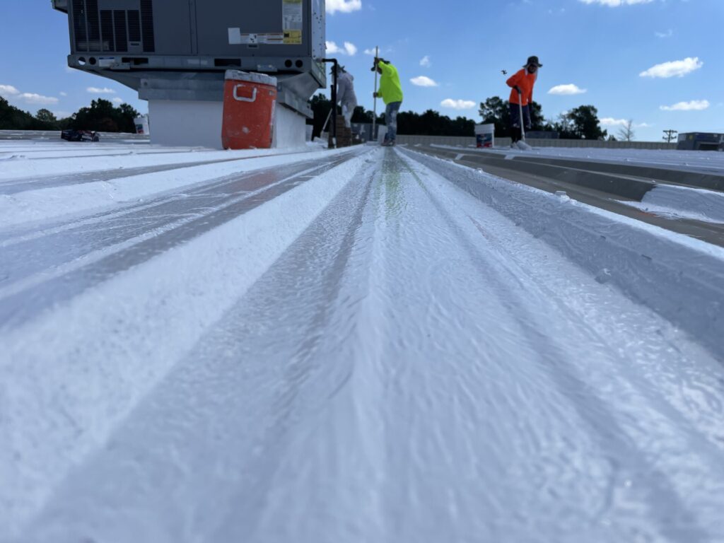 Low-angle view of the nearly complete white silicone roof coating, Conroe, TX