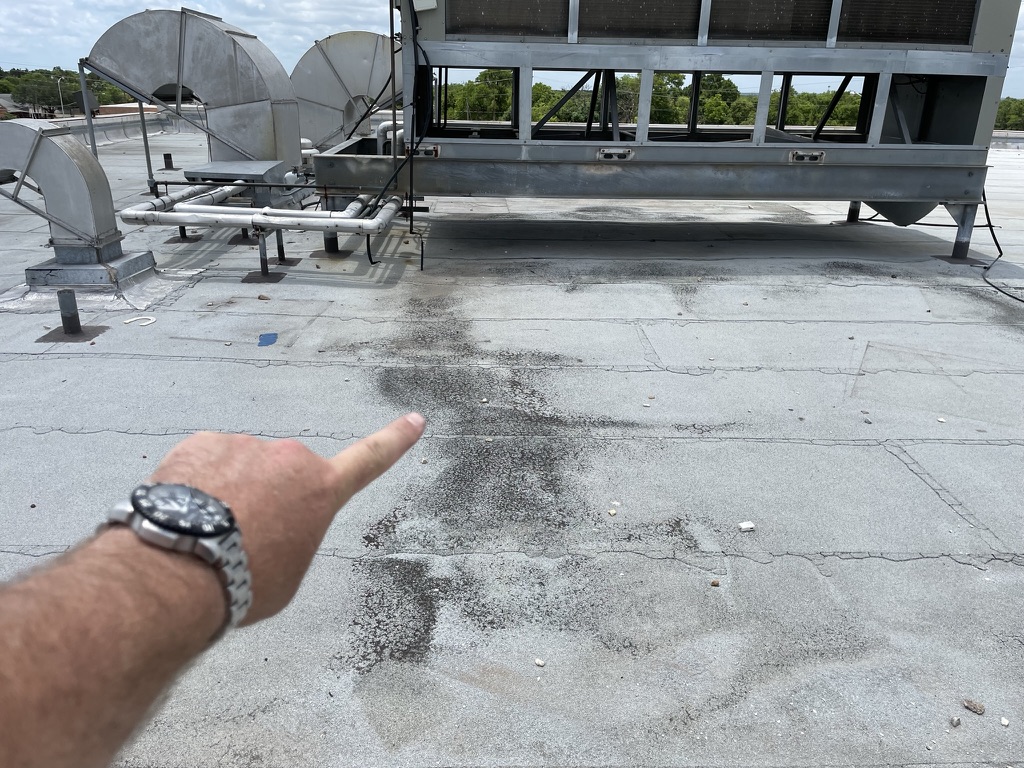 Water damage from the rooftop chiller unit dripping onto the flat roof, Dallas, TX