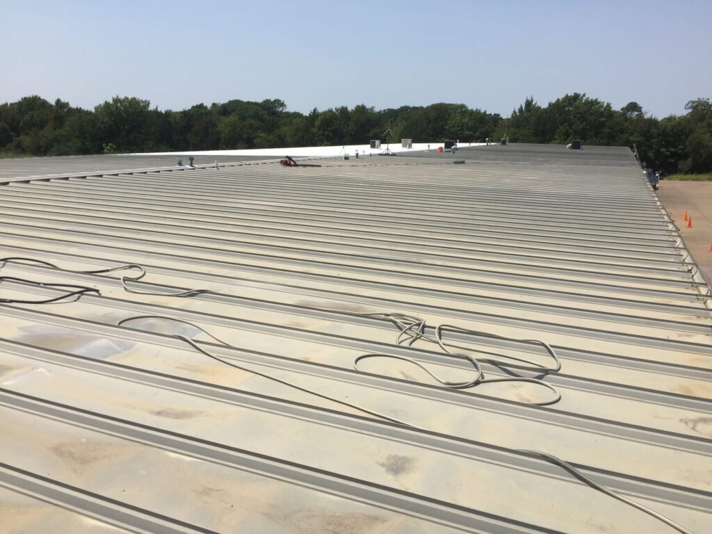 Existing metal roofing system before acrylic coating at the Carey Cox Company, 180 Industrial Blvd, McKinney, TX