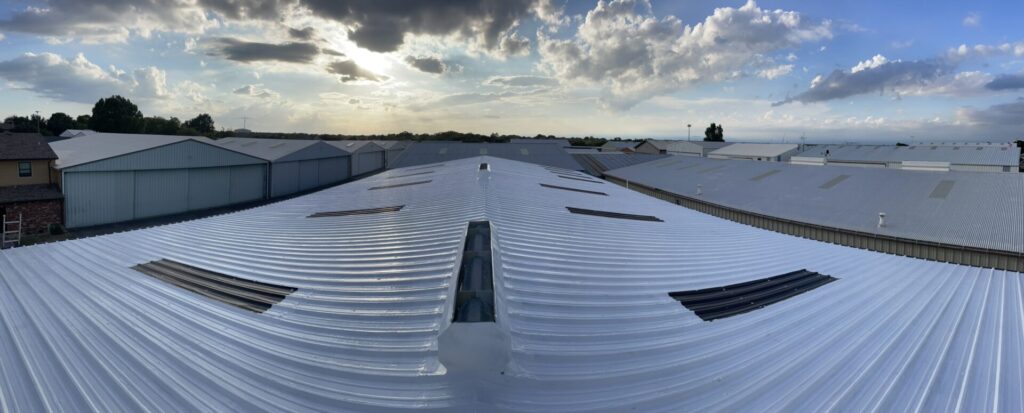 Completed white metal roof coating around skylights at 10010 N. American Lane in McKinney