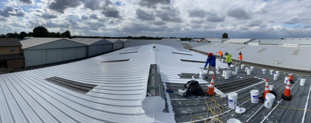Wide view of partially coated metal roof and rooftop materials during the McKinney restoration
